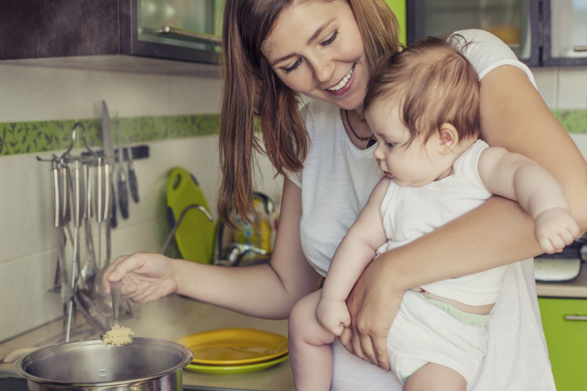 Madre con bebé cocinando alimentos