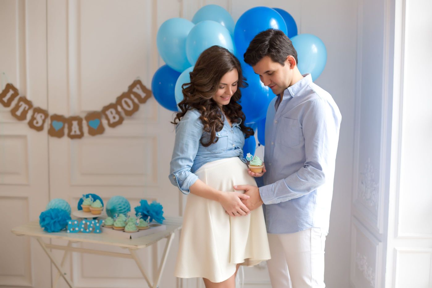 pareja en un baby shower tocando la barriga de la futura mama